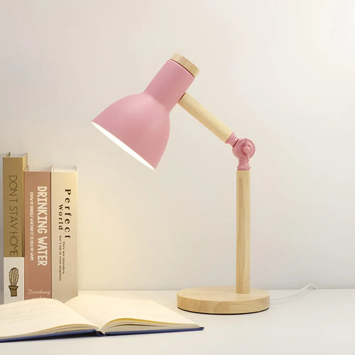 Pink desk lamp angled over an open book