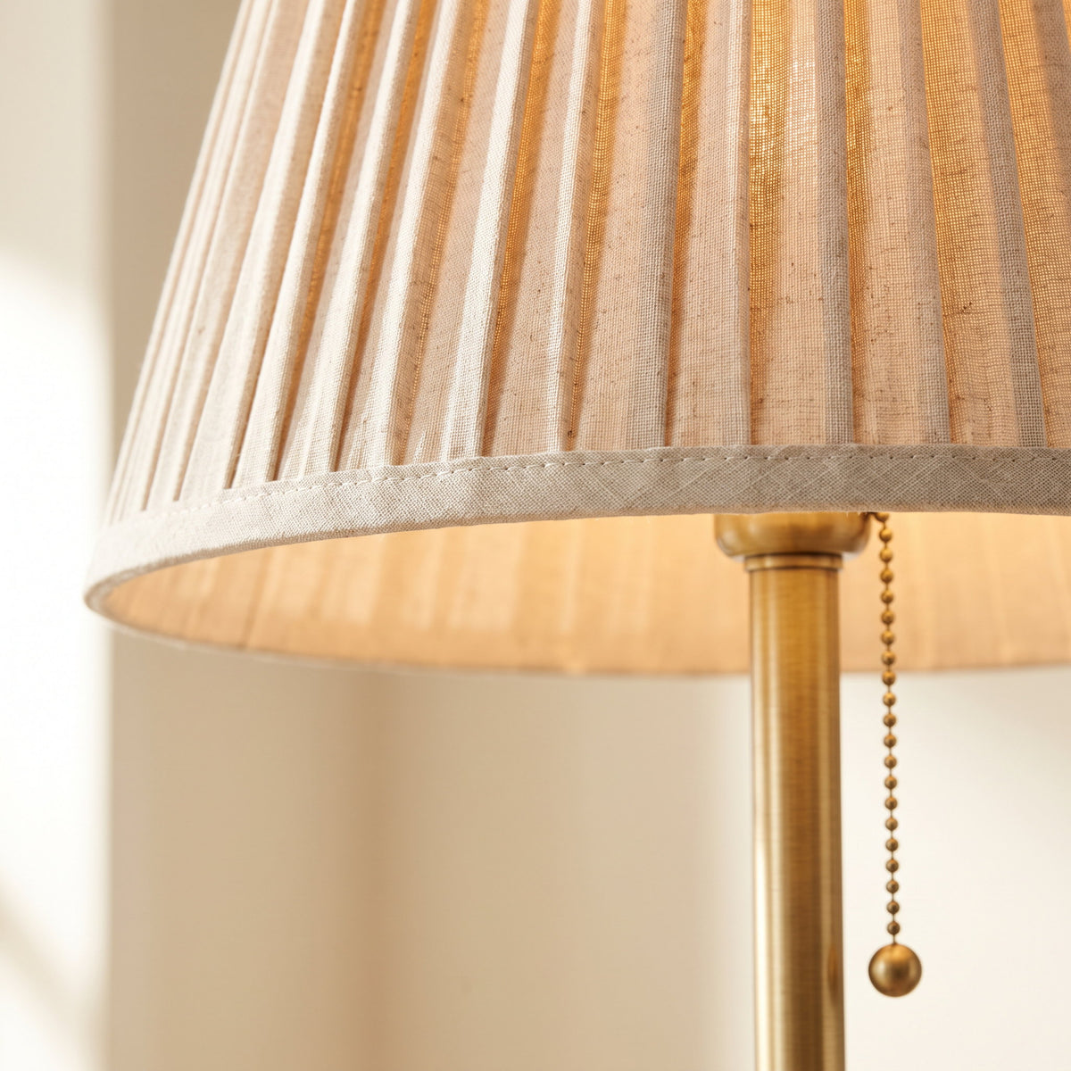 Close-up of the pleated shade and brass pull chain on the Alma lamp, Style Room