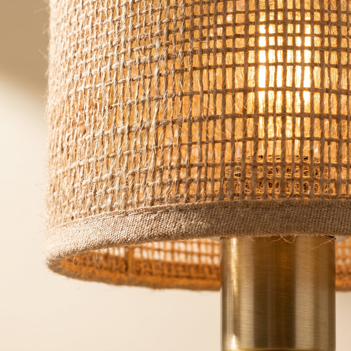 Close-up of the woven jute shade glowing above the brass stem, Style Room