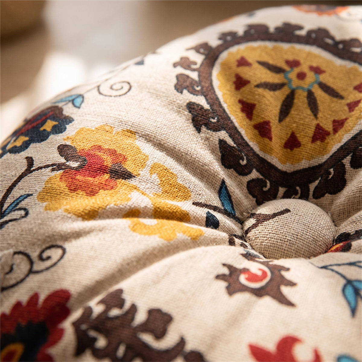 Close-up of the folk floral print and gathered seam on the Bela round cushion, Style Room