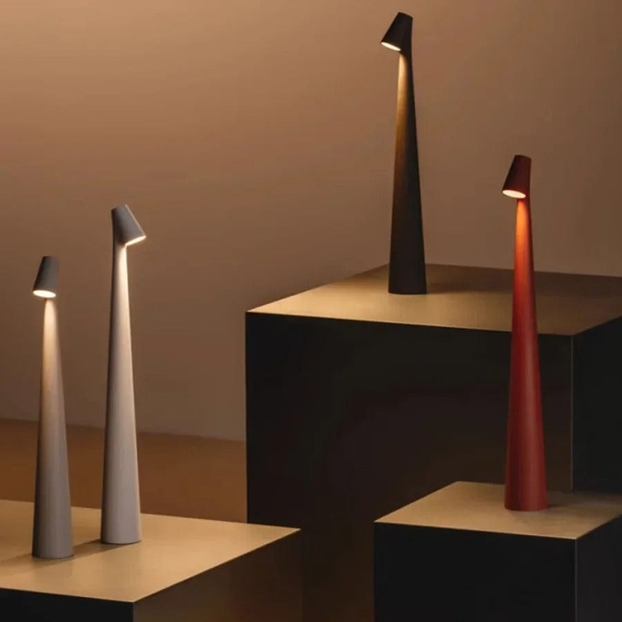 Four Bexley table lamps in grey, white, black and red arranged on stepped plinths