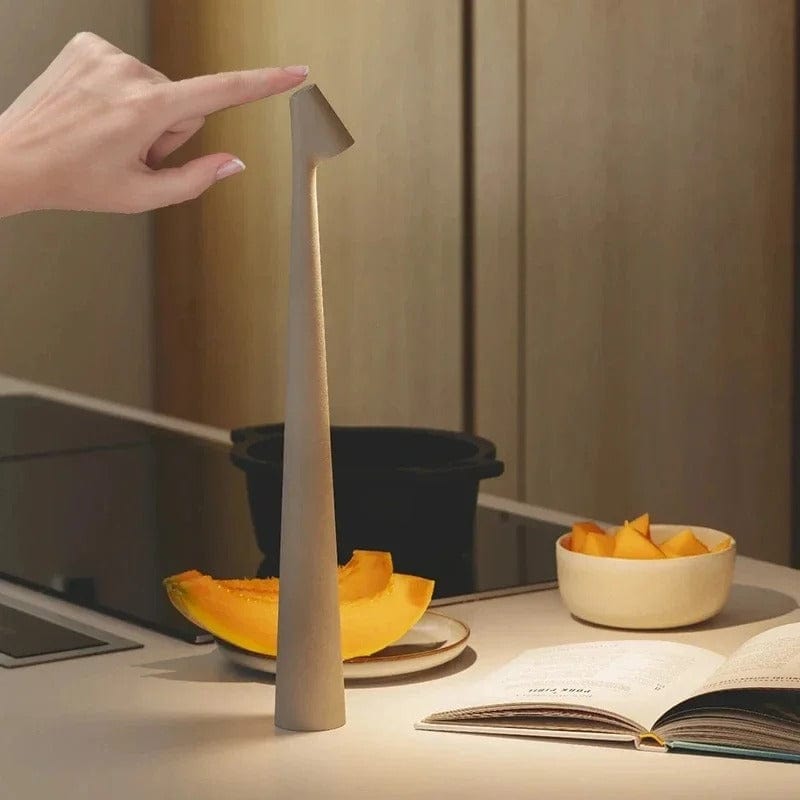 Hand touching the head of the Bexley table lamp on a kitchen counter