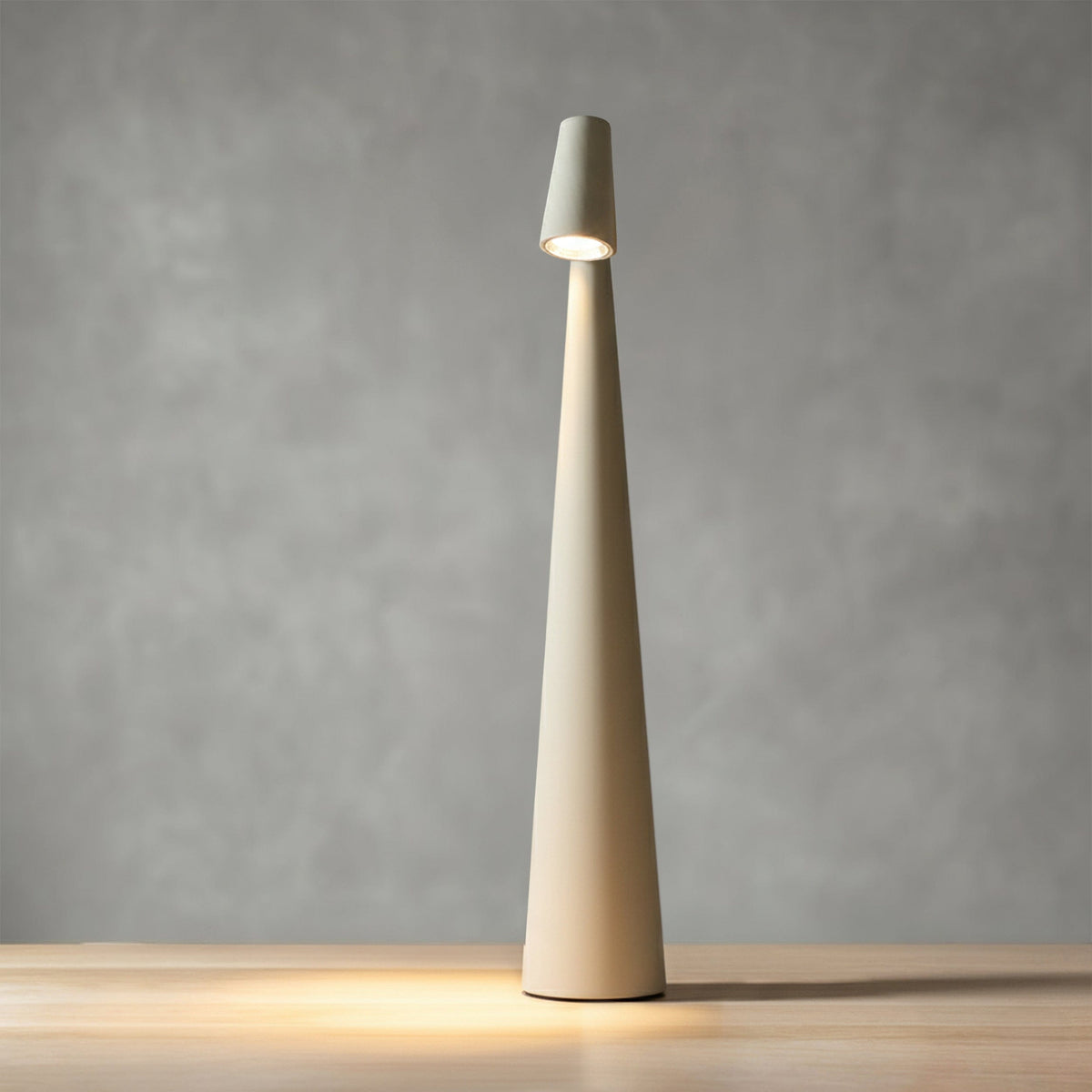 Bexley table lamp in white, lit against a grey wall