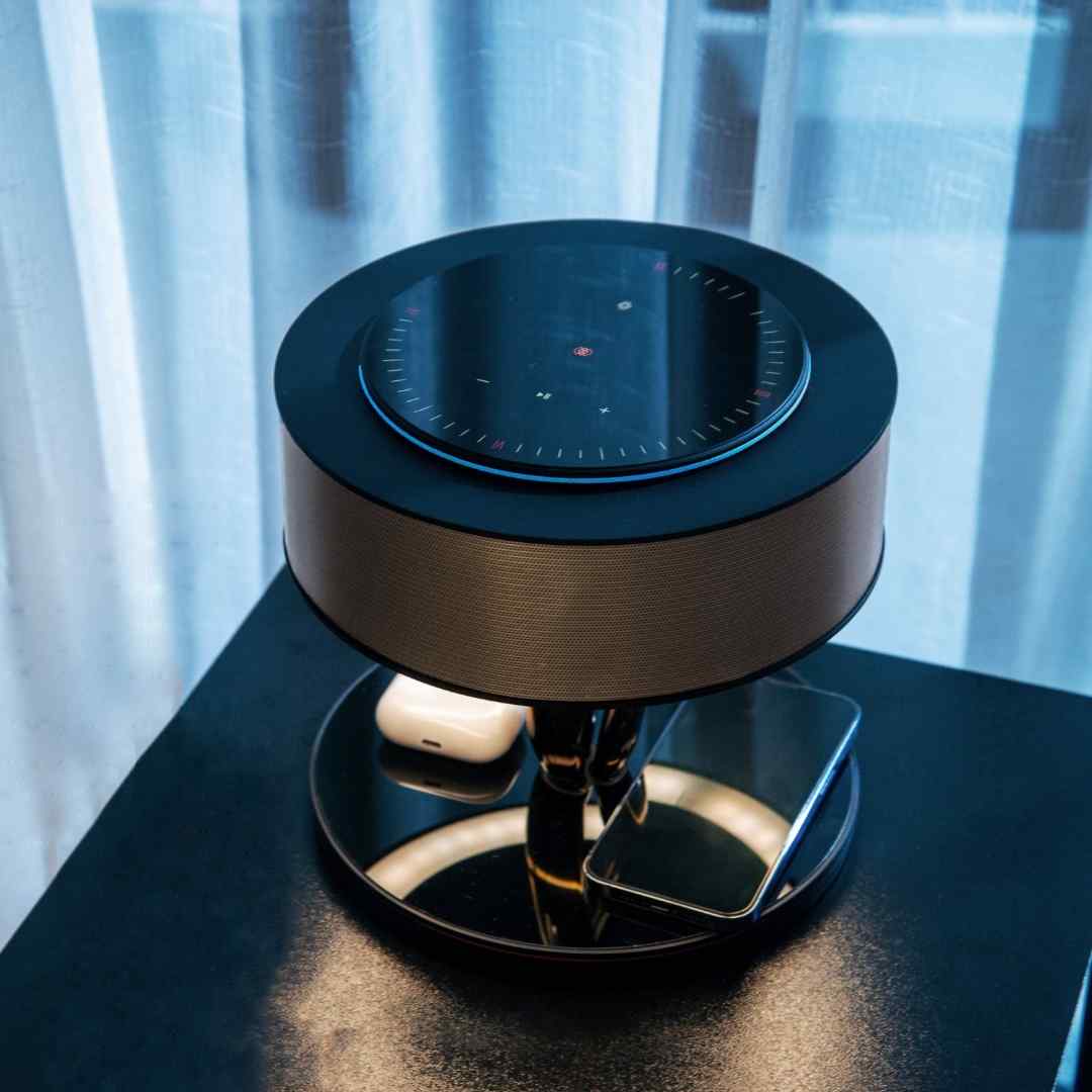 Bexon table lamp on a black nightstand with earbuds resting on the charging surface