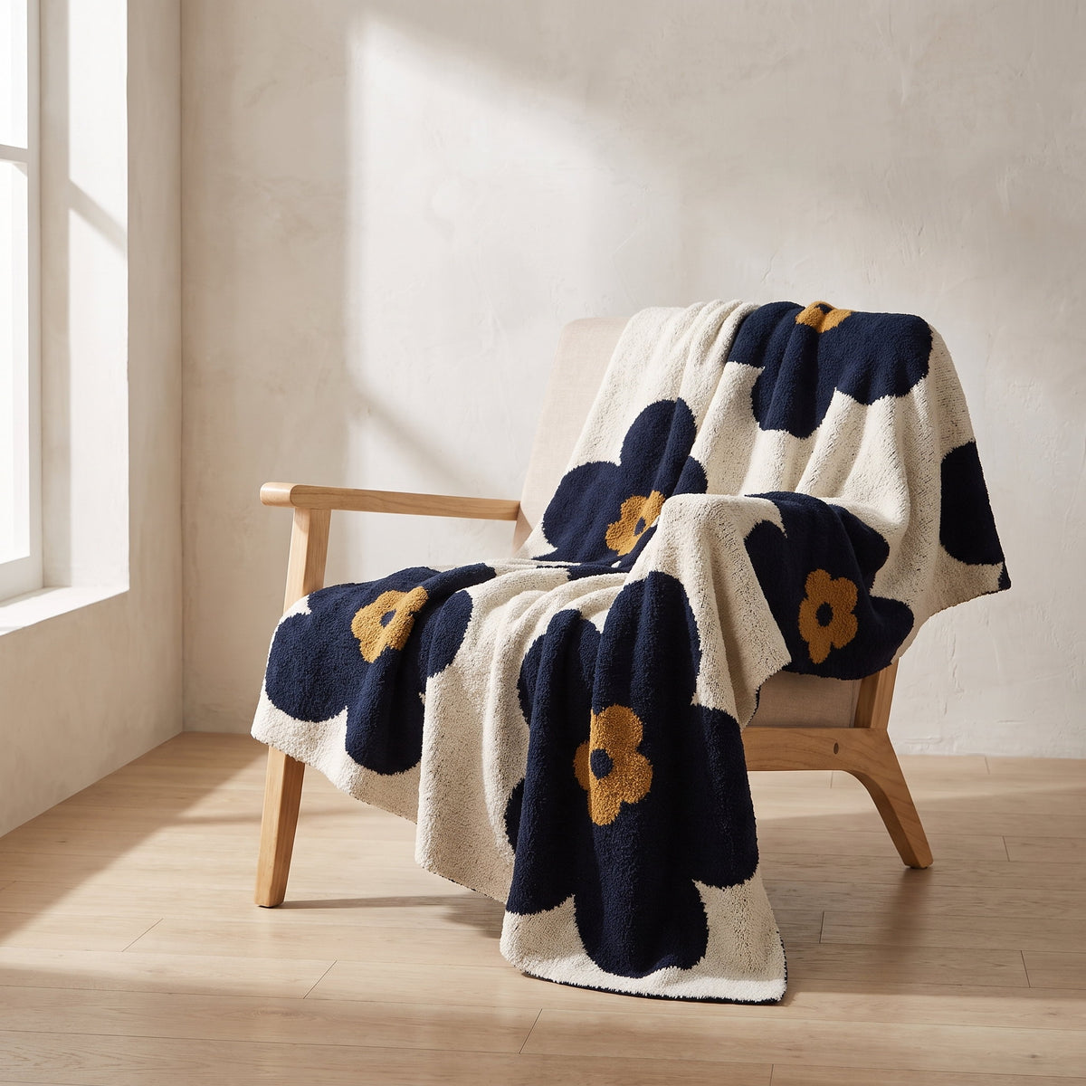 Bloom floral knitted blanket draped over a pale oak lounge chair, Style Room