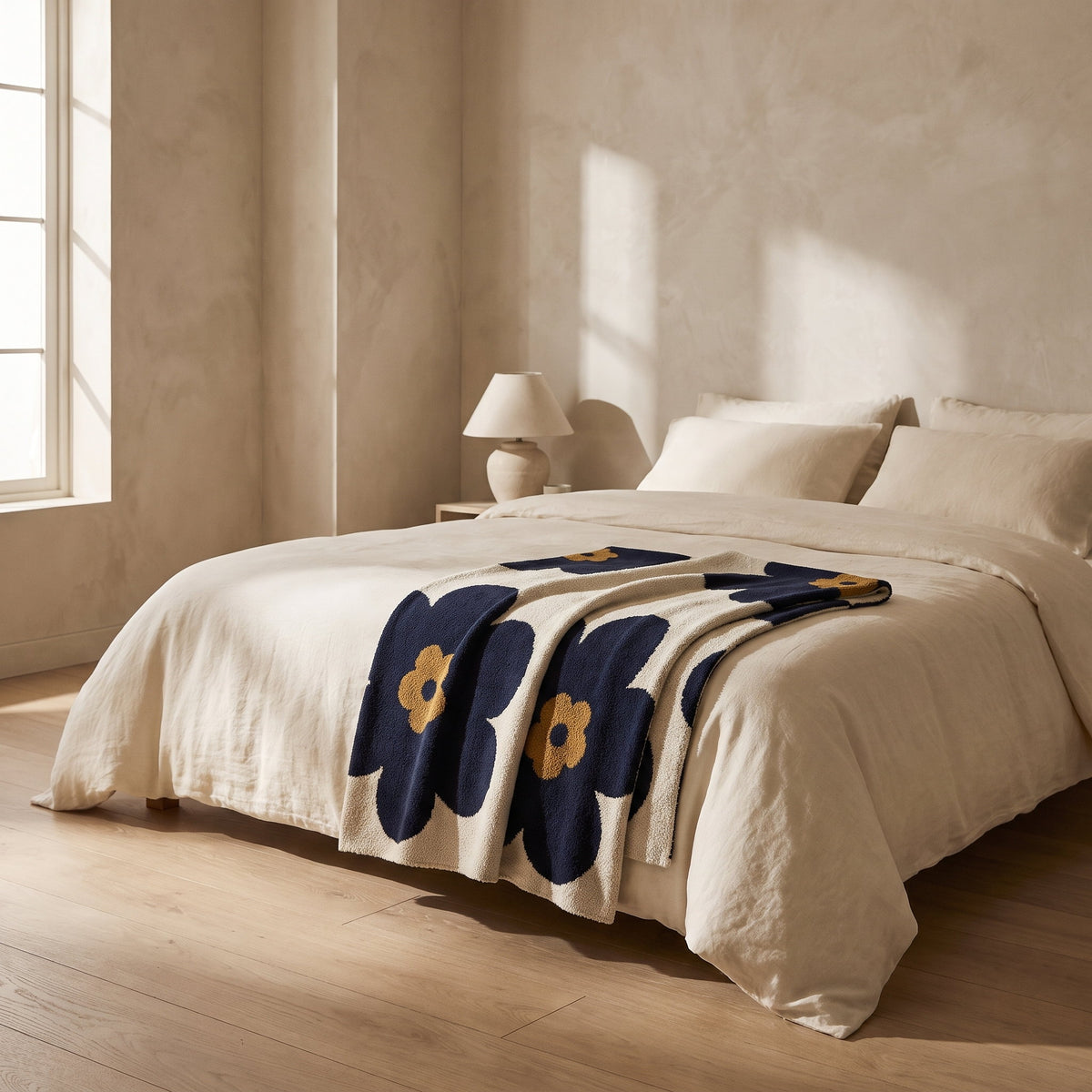 Bloom floral blanket folded across a cream linen bed, Style Room