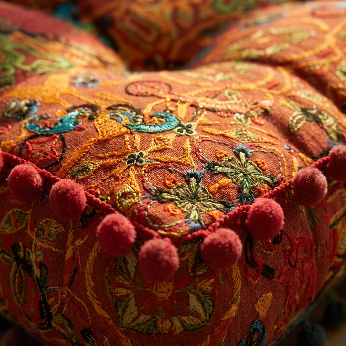 Close-up of the embroidery, quilting and pom-pom trim on the Blythe floor cushion, Style Room