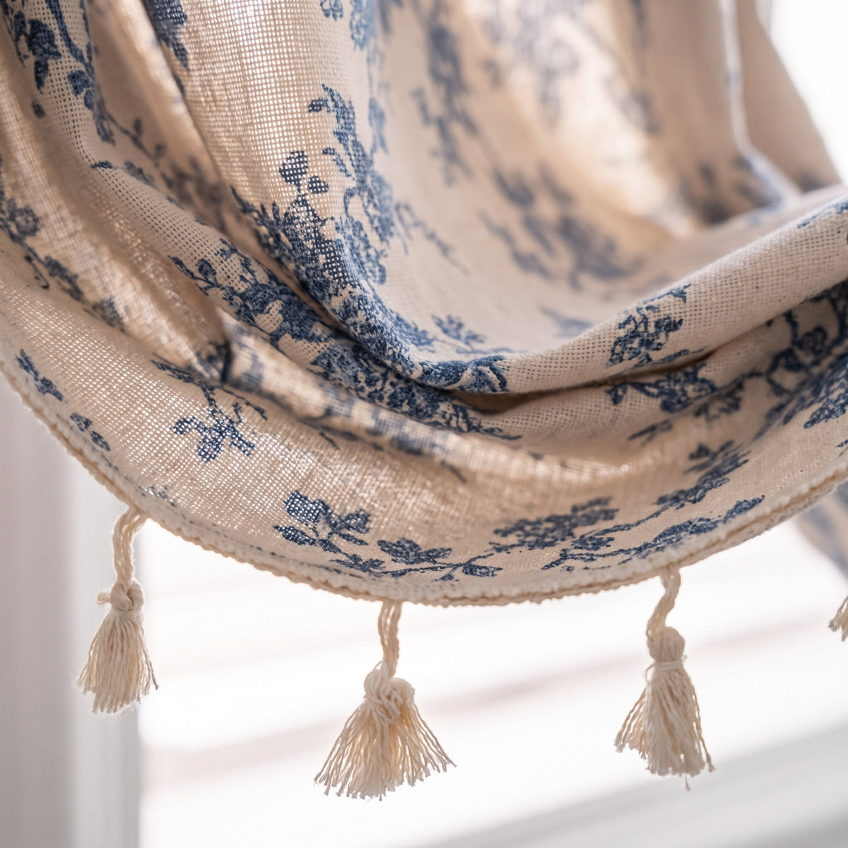 Close-up of the blue floral print and cream tassel trim on the Blythe curtain, Style Room
