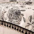 Close-up of the black floral print and tassel fringe of the Blythe tablecloth, Style Room