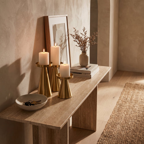 Brenna gold candle stands lit on a travertine console, Style Room