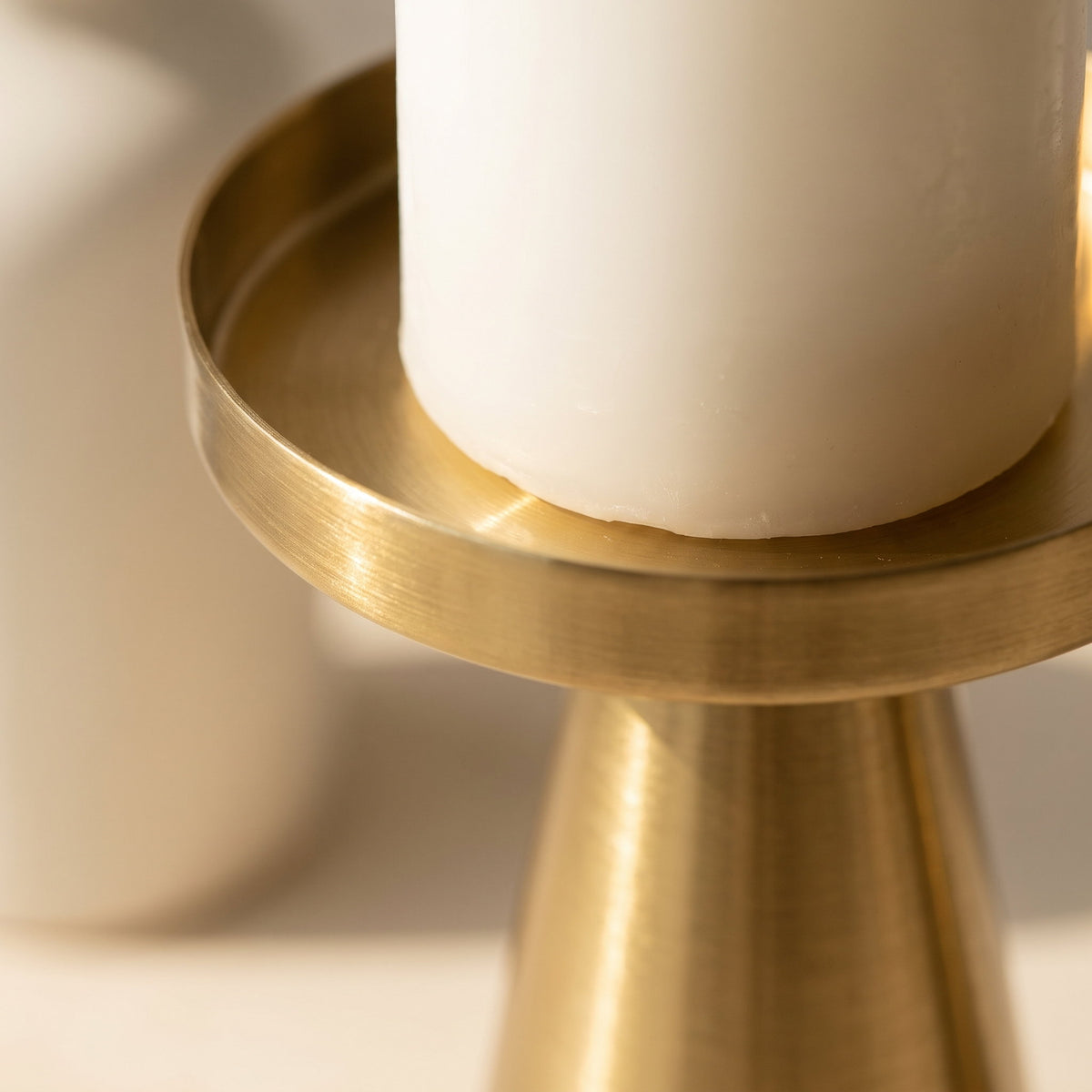 Close-up of the brushed brass plate of the Brenna candle stand, Style Room