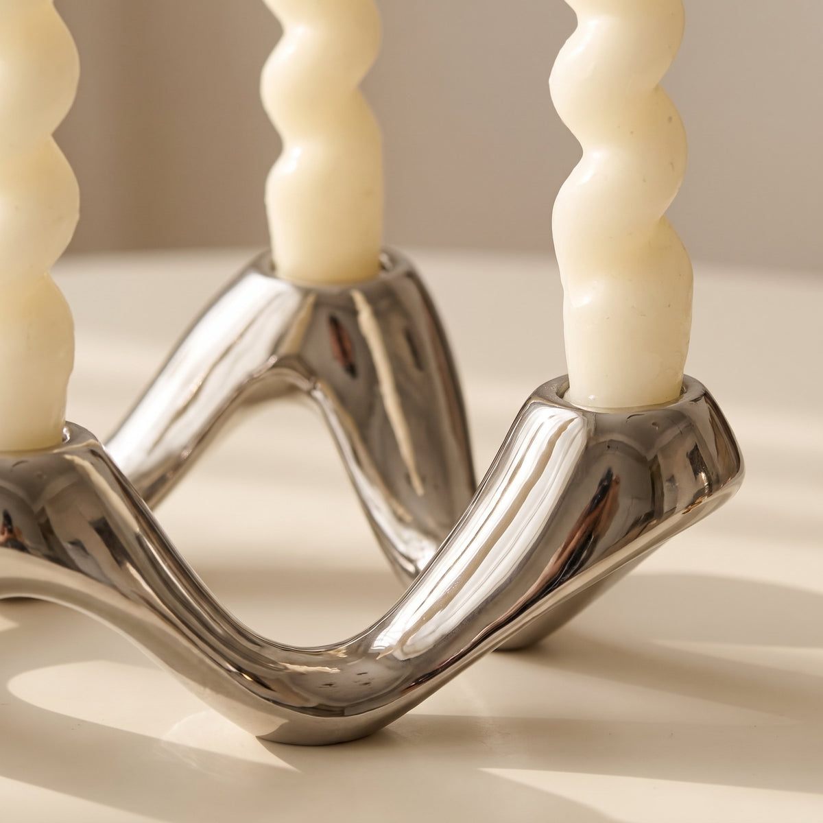 Close-up of the polished rippled arms of the Celora candle holder, Style Room