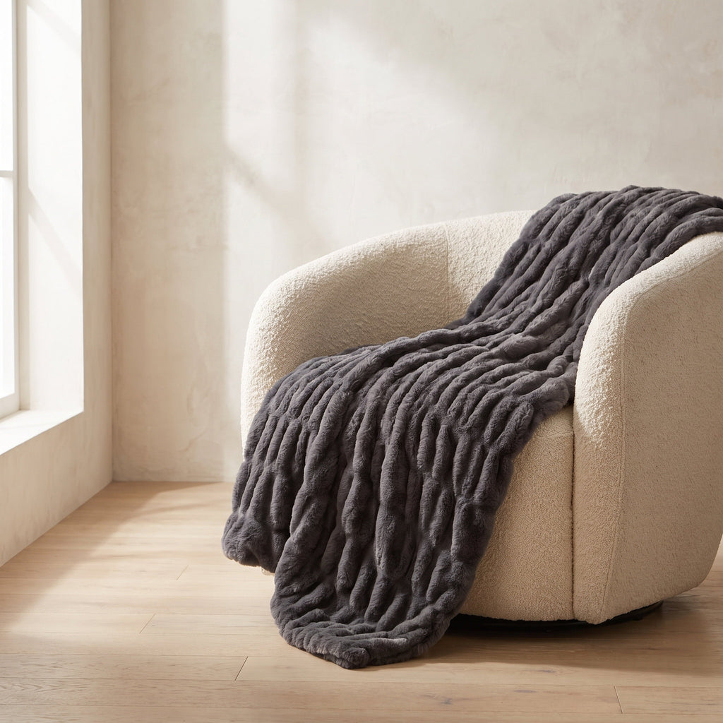 Cora charcoal faux fur throw draped over a cream boucle armchair, Style Room