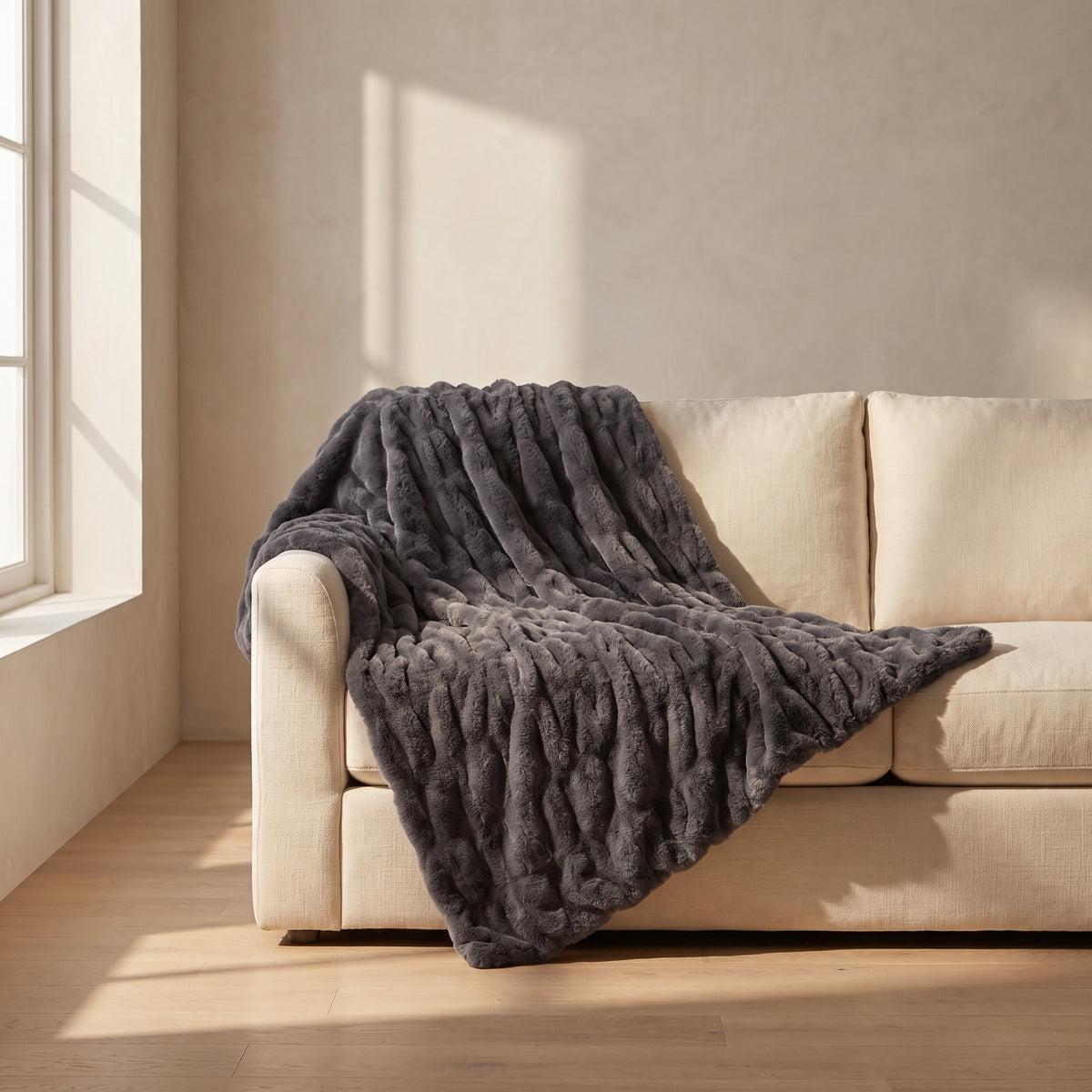 Cora charcoal faux fur throw over a cream linen sofa, Style Room