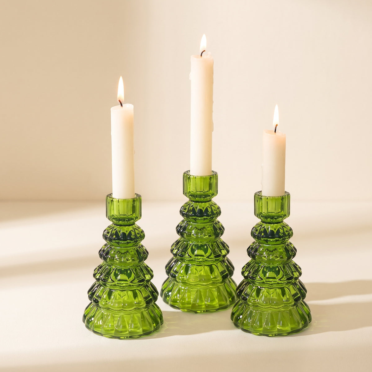 Cresta glass candle holders, set of three green Christmas-tree shaped holders with taper candles on a cream background