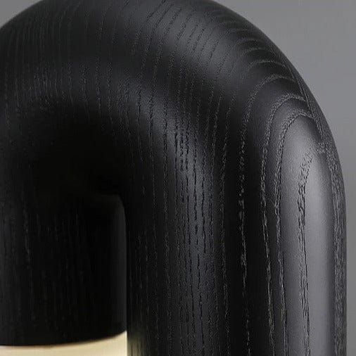 Close-up of the Diora lamp in black stain, showing the wood grain across the curve