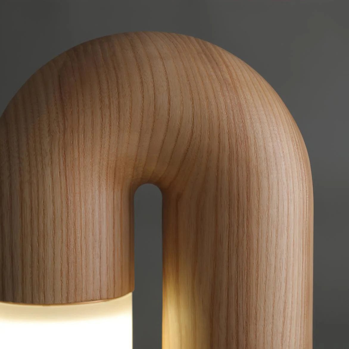 Close-up of the Diora arch in natural oak with the frosted shade lit beneath