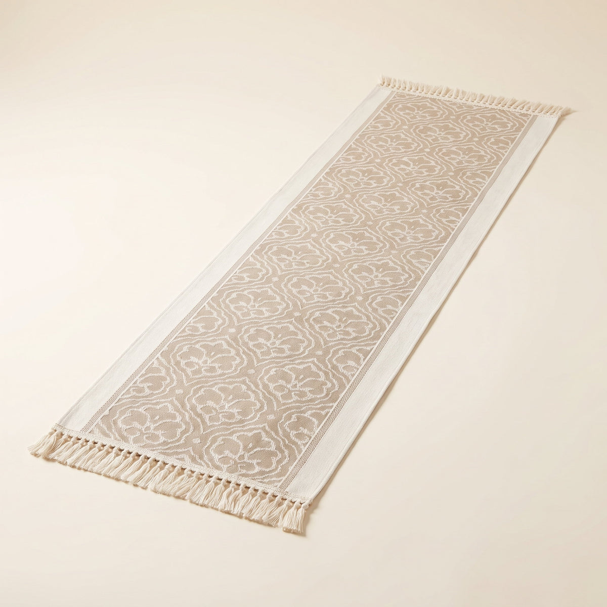 Dune damask jacquard table runner laid flat with tassel fringe at both ends, full view