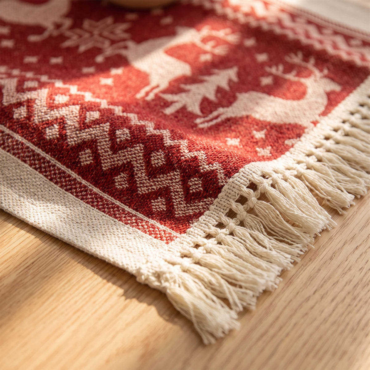 Detail of the Eldon elk table runner showing the red and cream jacquard weave and cream tassel fringe