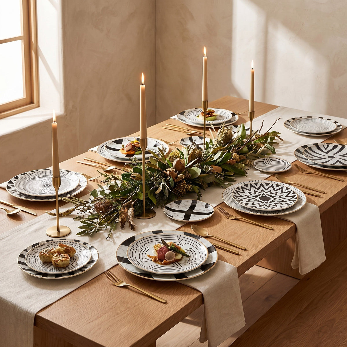 Juno plates set across a long wooden dining table with taper candles