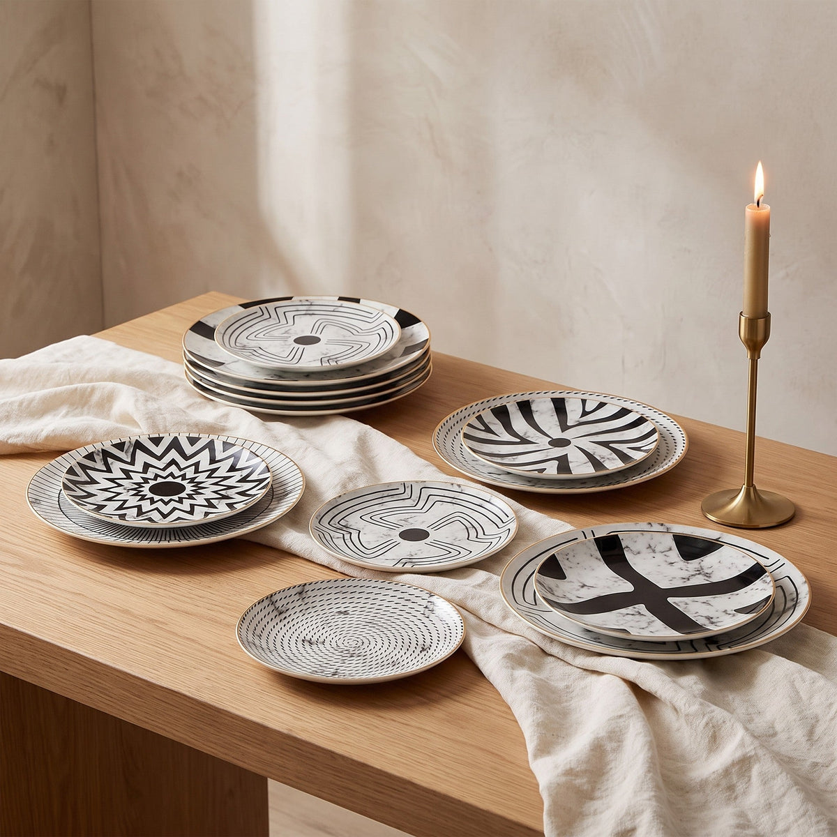 Juno plates arranged on a console table beside a brass candlestick and linen cloth