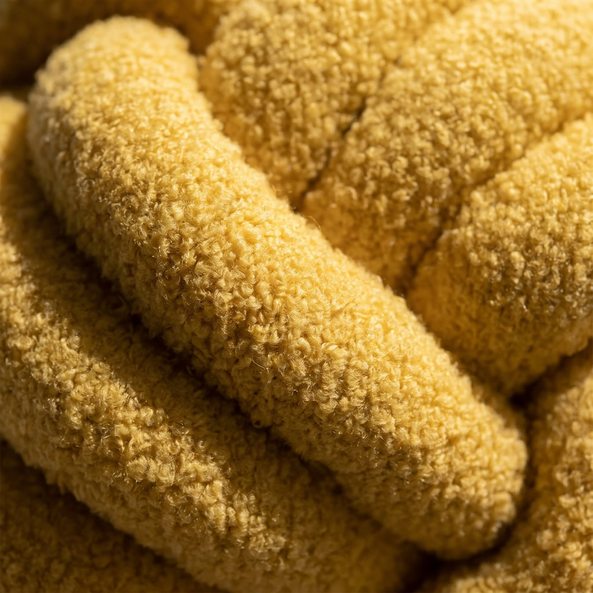 Detail of the Kora cushion showing the looped yellow lambswool boucle nap at a knot crossing