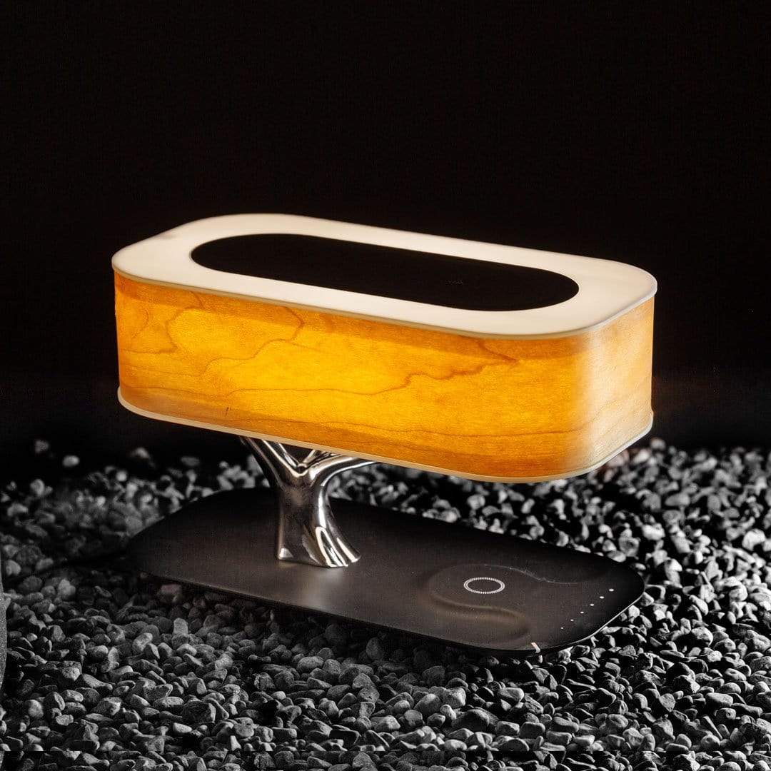 Liora table lamp lit on a round side table against a sheer curtain