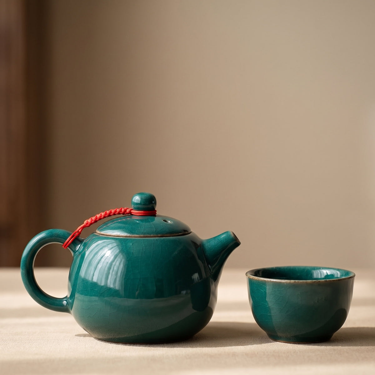 Close detail of the teal glaze on the Lotus teapot beside one small cup, Style Room