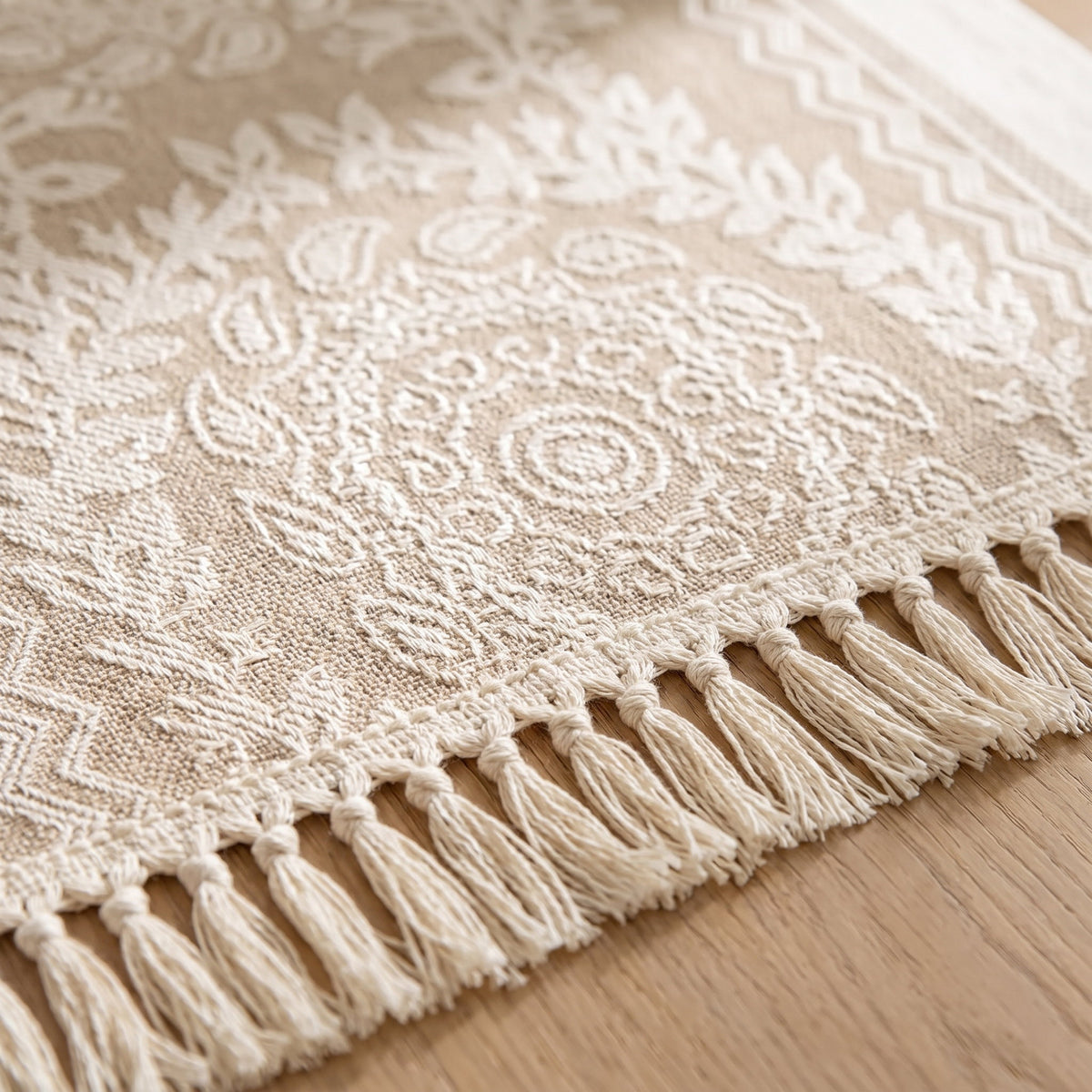 Close-up of the damask lace medallion and knotted fringe of the Luna runner, Style Room