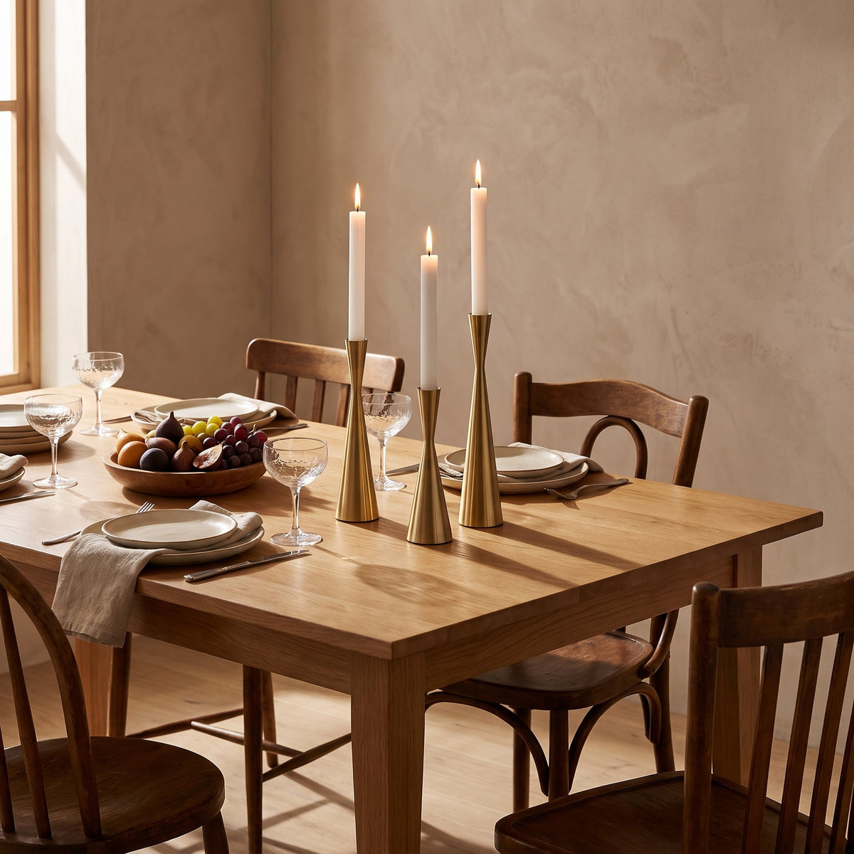 Nexa brass candlestick set lit on a pale oak table, Style Room