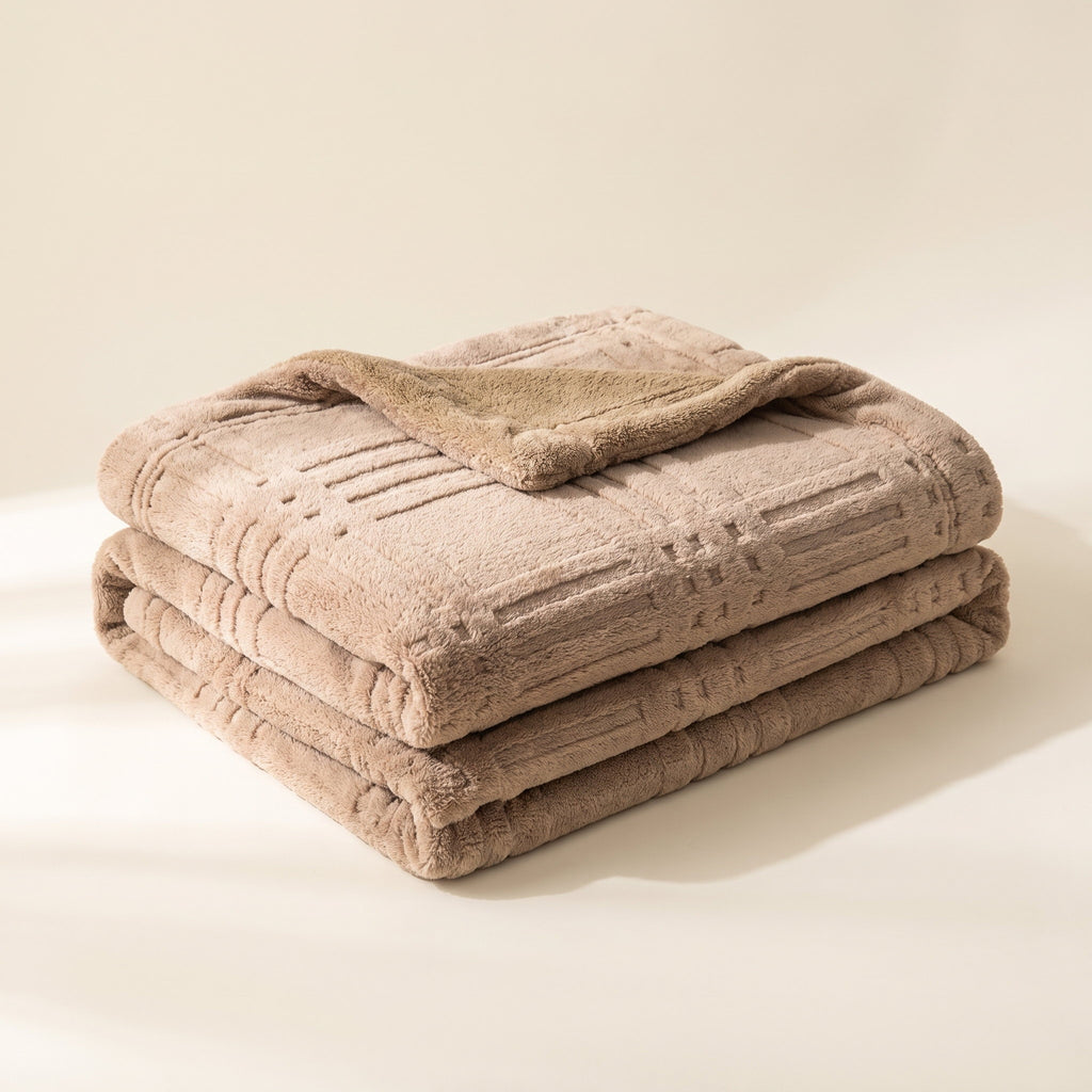 Pavo embossed grid blanket in dusty pink double-layer microfiber, neatly folded on a cream background