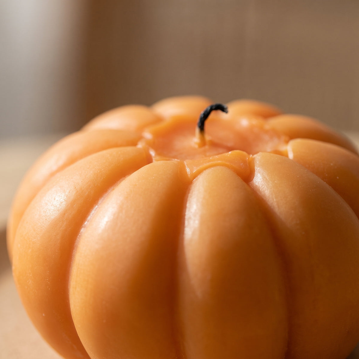 Close detail of the ribbed wax surface and wick of the Pippin pumpkin candle, Style Room