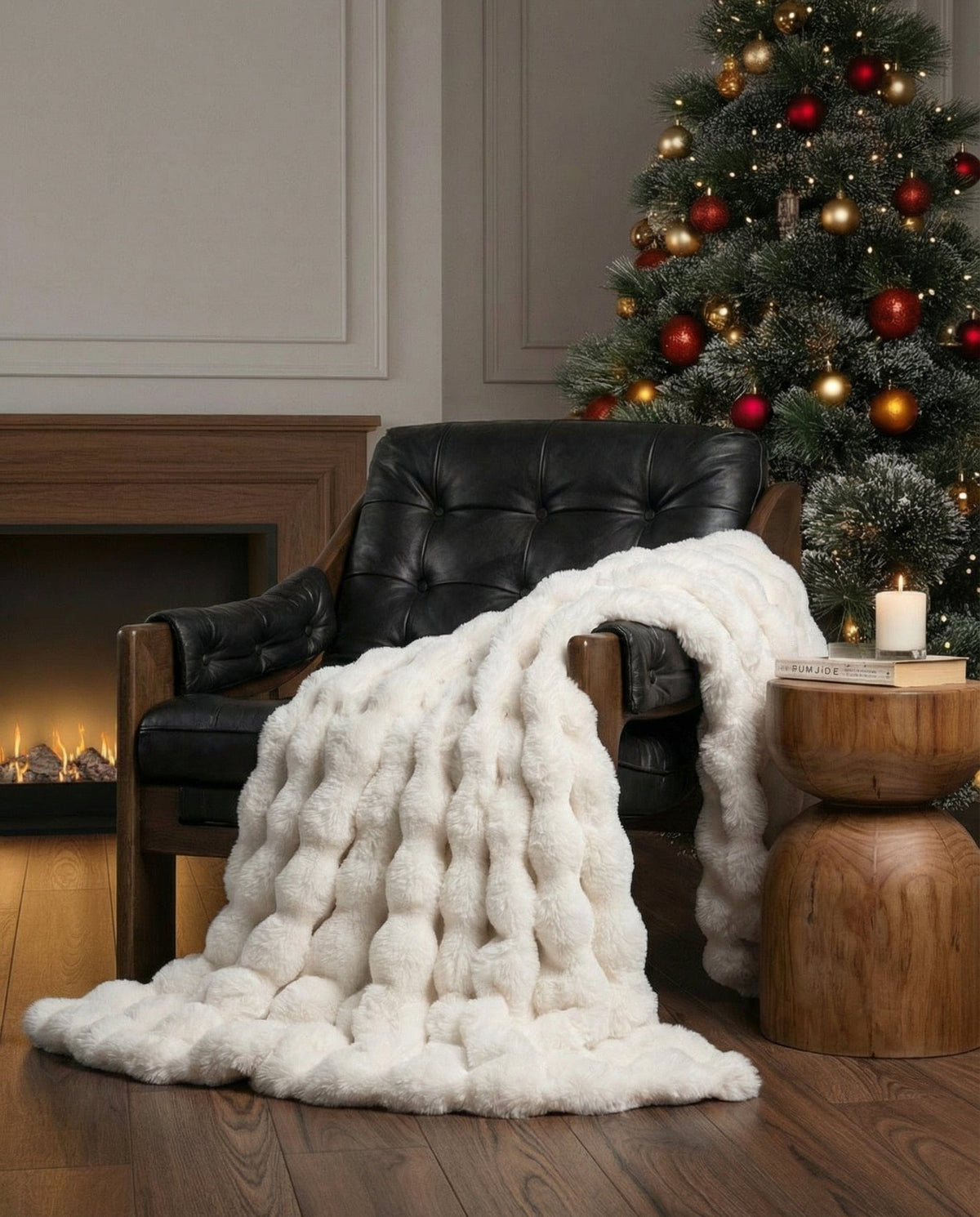Raven throw in off-white draped over a black leather armchair beside a fireplace