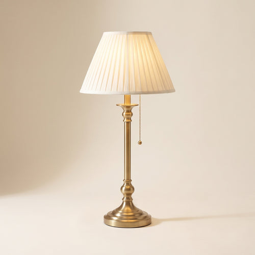 Rowan table lamp in brushed antique brass with a cream pleated shade, front view