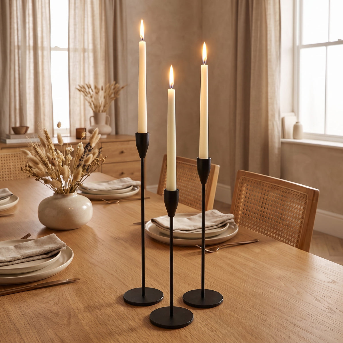 Sable black candlesticks lit on a laid oak dining table in evening light, Style Room