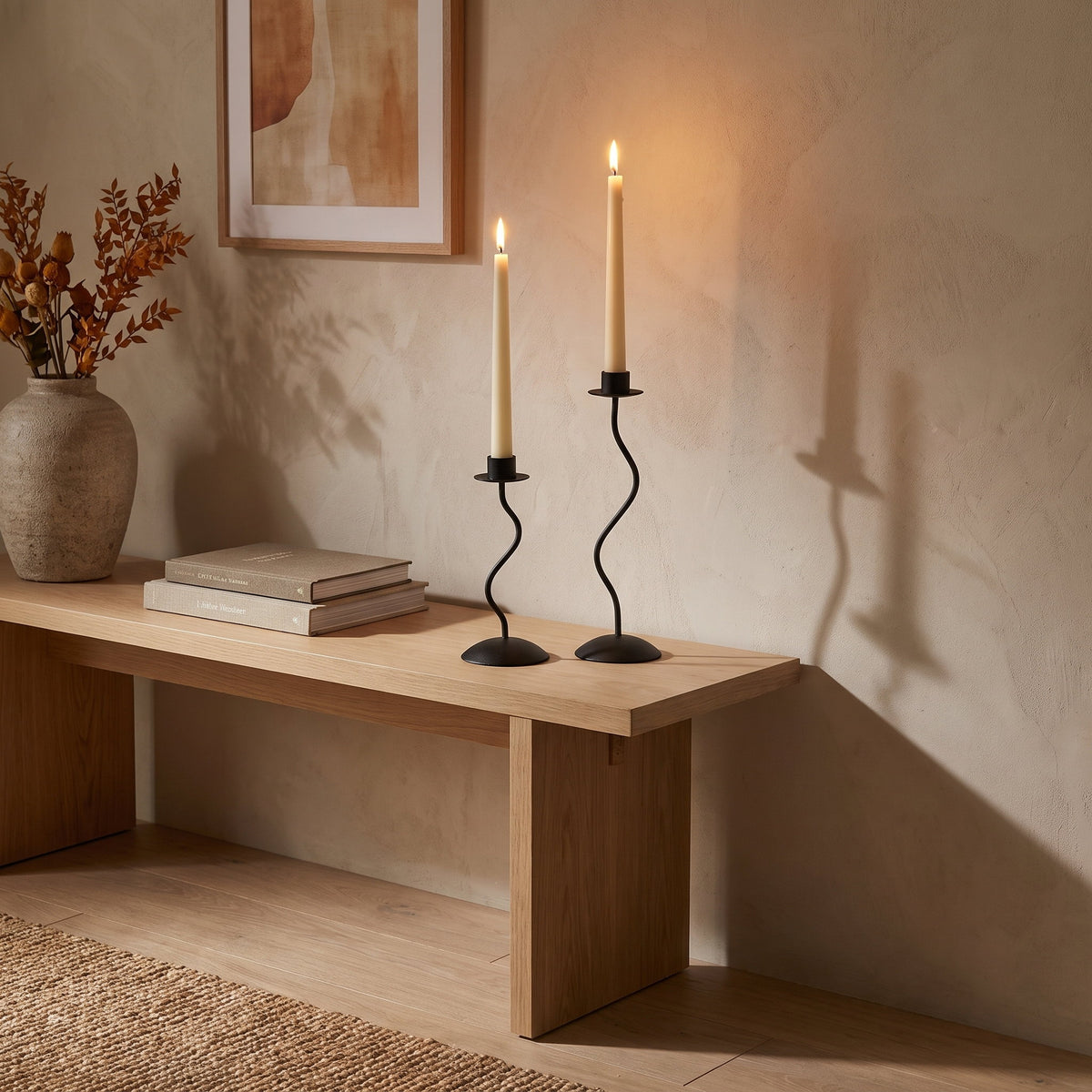 Black wavy iron candle holders lit on an oak console in a warm sitting room, Style Room