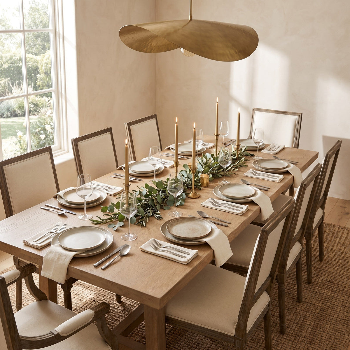 Dining table laid with Sierra cutlery under a brass pendant light