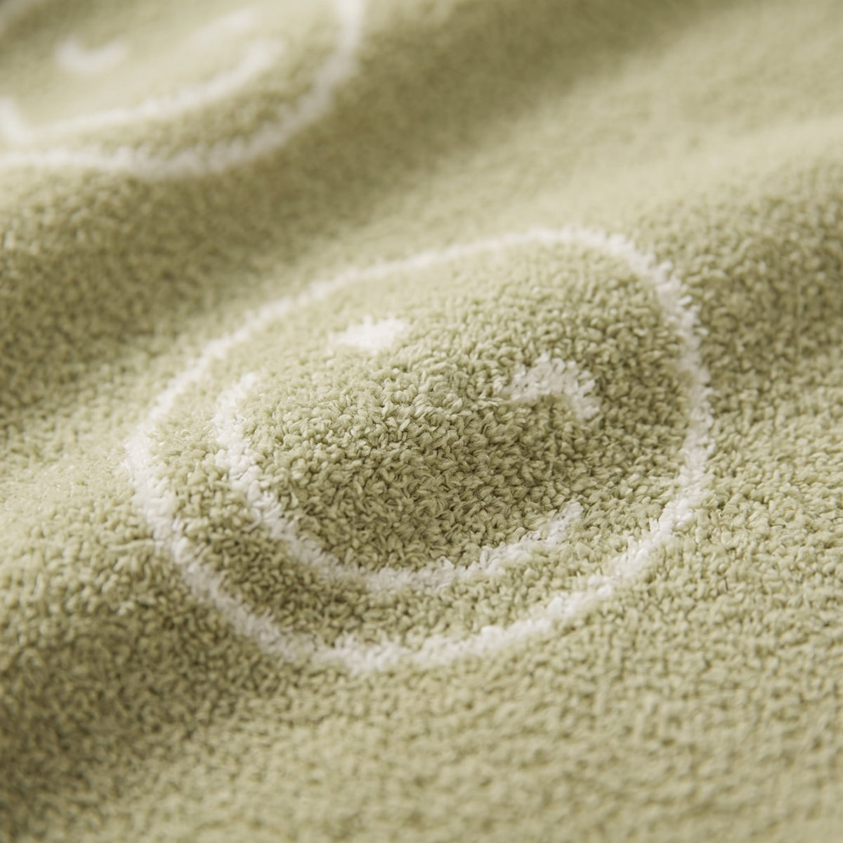Close-up of a smiley motif on the Soleil plush blanket, Style Room