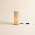 Soren night light with a linen shade on a wood base, lit, with its USB cable, on a cream background, Style Room