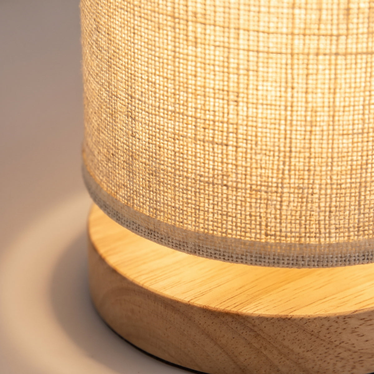 Close detail of the linen weave meeting the turned wooden base of the Soren night light, Style Room