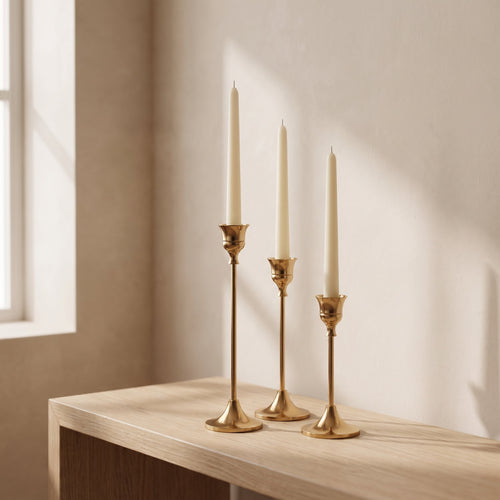 Vero brass taper candle holders with ivory candles on a pale oak console