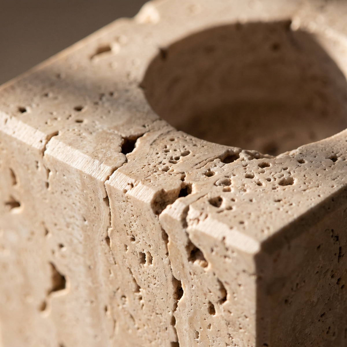 Close detail of the pitted travertine surface and the rim of one candle well, Style Room