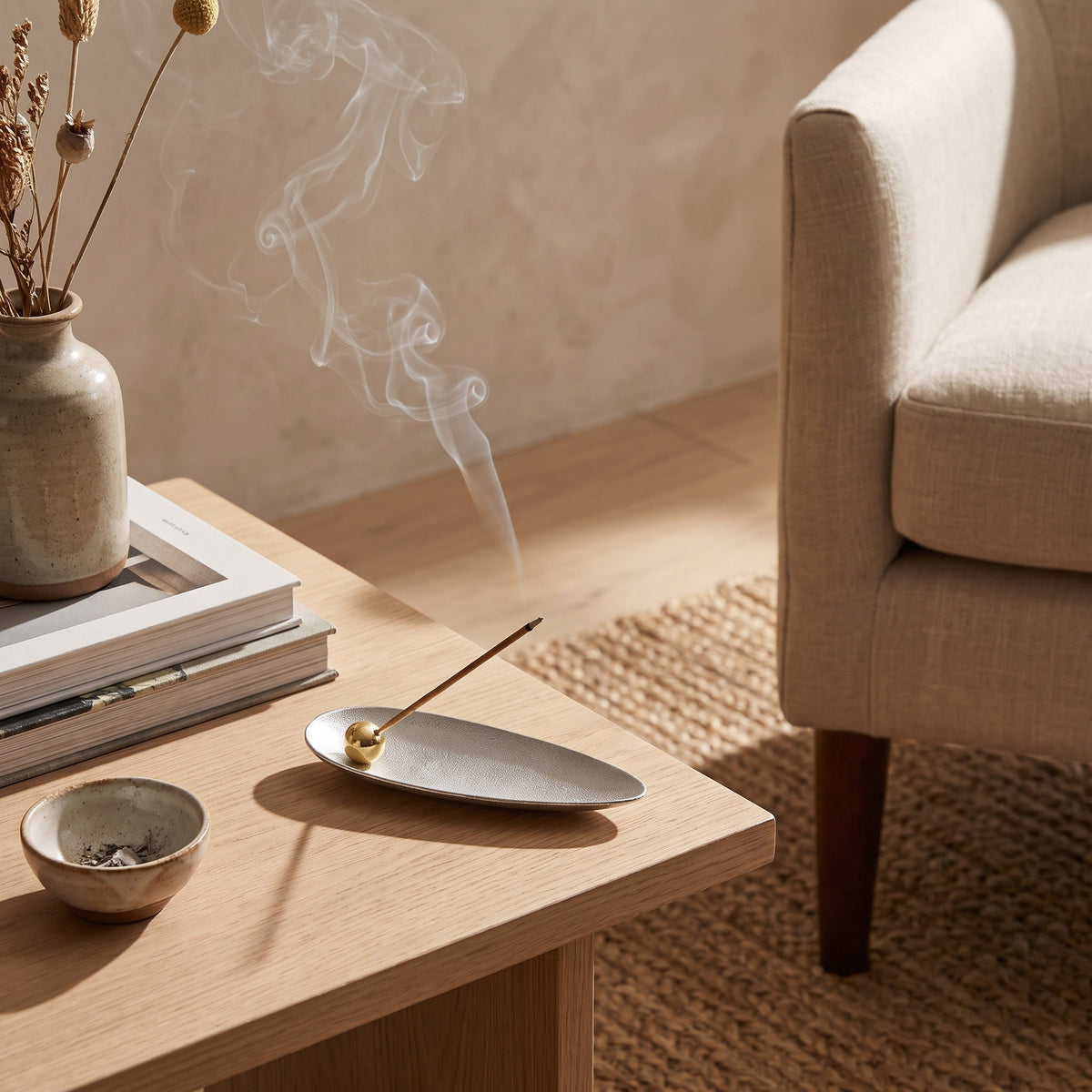 Brushed silver leaf incense holder alight on an oak side table, Style Room